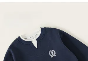 Detailed macro view of the collegiate B letter embroidery on blue sweatshirt fabric