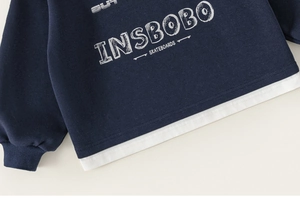 Detailed macro of dark blue sweatshirt with layered hem and vintage skateboarding print