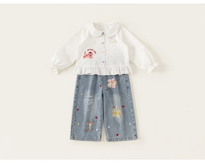 Dettaglio camicia bianca bimba con colletto Peter Pan e set pantaloni jeans larghi