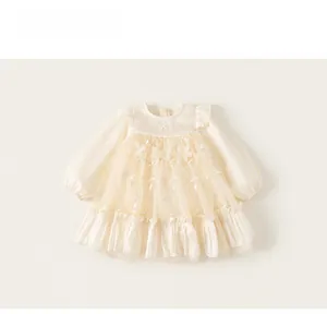 Detail of baby girl tulle dress featuring 3D flowers, embroidery, and ruffled mesh sleeves