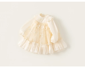 Close-up of elegant floral lace embroidery and mesh layers on a girls' ivory dress