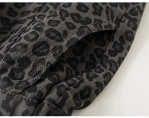 Detailansicht eines grauen Kinder-Hoodies mit Leopardenmuster, Köperbindung und Taschennaht