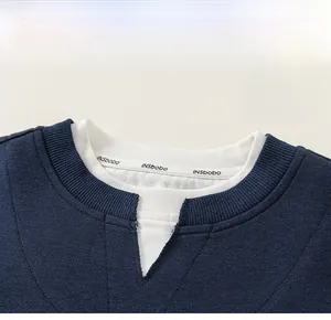 Detail of navy blue kids sweatshirt featuring a faux-layered crew neck and premium cotton texture