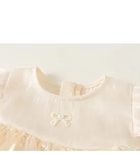 Detail of cream tulle dress featuring pearl bow embroidery and silky ribbed texture