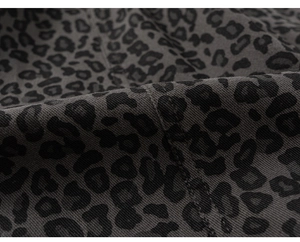 Detailaufnahme von dunkelgrauem Twill-Stoff mit schwarzem Leopardenmuster für Kinder