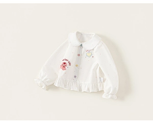 Dettaglio della camicetta bianca a pois per bambina con bottoni colorati e ricami