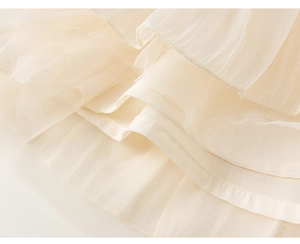 Detail of multi-layered soft mesh tulle and fine stitching on a girl's ivory dress