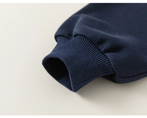 Detailed macro view of navy blue ribbed cuffs on kids sweatshirt with premium stitching