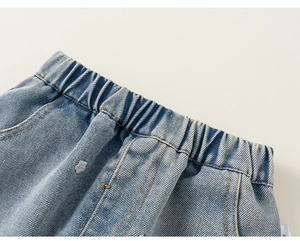 Dettaglio dei jeans in denim lavato azzurro con vita elastica e cuciture delle tasche