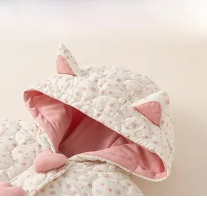 Detail of floral quilted baby hood with cat ears and pink heart button closure