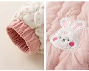Detail of pink quilted kids jacket with floral ribbed cuffs and cute bunny applique