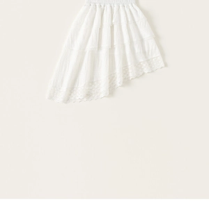 Detail of white asymmetric mesh skirt showing ruffled lace edges and fabric texture