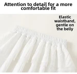 Detail of white mesh skirt featuring elastic waist with intricate lace trim and pleats