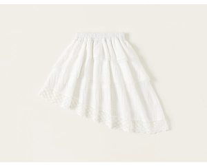 Detail of girls white tiered tulle skirt featuring an irregular hem and lace trim