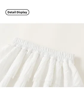 Close-up detail of girls white tiered tulle skirt with elastic waist and lace trim edges