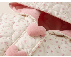 Close-up of quilted floral kids hooded jacket with soft rose pattern and pink heart detail