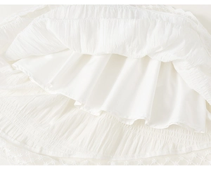 Close-up of white tulle skirt featuring delicate lace embroidery and layered fabric texture