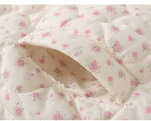 Macro view of pink floral quilted fabric detail with fine diamond stitching and side pocket