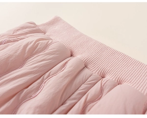 Close-up of pink quilted fabric with wavy stitching and thickened ribbed cuffs for kids