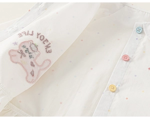 Détail de chemise en coton pour fille avec pois colorés et boutons pastels vibrants