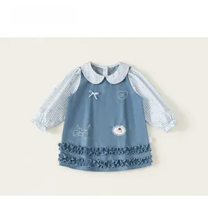 Detail of girl's dress with Peter Pan collar, bow, and heart embroidery detail