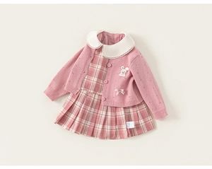 Detail der rosa Strickjacke mit Hasenstickerei und kariertem Kleid für Mädchen