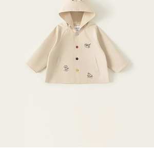 Detail view of beige toddler hoodie with colorful buttons and black animal line drawings