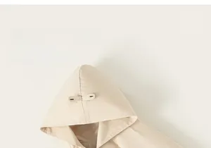 Close-up of cream toddler hooded jacket with decorative button details and soft cotton fabric