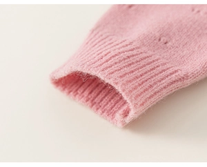 Detailaufnahme der rosa Strickpullover-Ärmel mit Rippbündchen und floralen Lochmustern