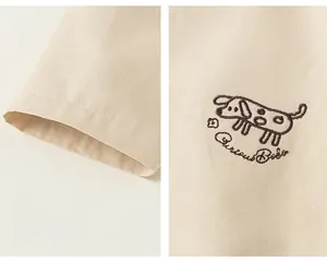 Detail of soft beige kids hoodie featuring fine cartoon dog embroidery and neat sleeve cuffs