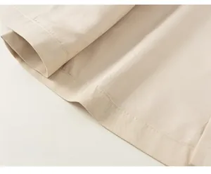 Detail of loose hem on toddler beige hooded jacket with durable double-stitched seams