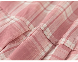 Detailaufnahme der rosa-weißen Karofalten an einem Mädchenrock im Schulstil-Design