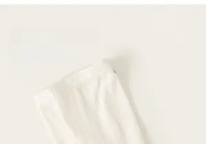 Détail de la taille en tricot côtelé doux sur le legging crème pour tout-petit
