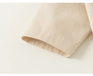 Detailed macro view of the beige cotton twill sleeve cuff with neat single-stitch seams