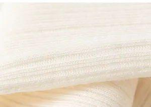 Détail macro du tissu en maille côtelée blanche douce montrant texture et élasticité
