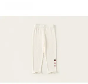 Détail du legging en maille côtelée blanc crème avec broderie lapin et cerise
