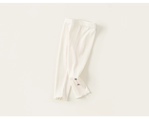 Détail de la maille côtelée et broderie cerise sur le legging beige pour tout-petits