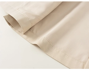 Macro shot of fine stitching and fabric texture on a beige toddler hooded jacket