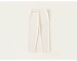 Détail du legging côtelé blanc crème avec taille élastique et ourlet ondulé doux
