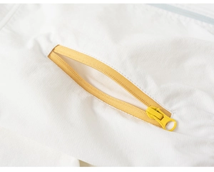 Detailed macro view of high-quality yellow resin zipper on white kids sun-protective jacket