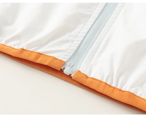 Macro detail of breathable white sun protection jacket with orange elastic hem and zipper