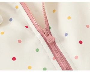 Macro shot of pink resin zipper and heart-shaped slider on polka dot girls' hoodie