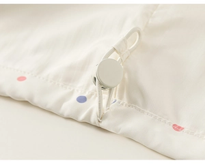 Dettaglio dell'orlo della giacca per bambini con pois colorati e coulisse elastica regolabile