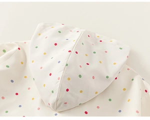 Dettaglio della stampa a pois colorati sulla felpa con cappuccio crema per bambine