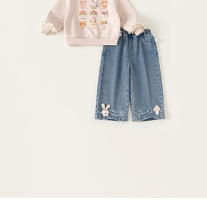 Dettaglio felpa rosa per bambina con stampe animali, pizzo e jeans in denim blu