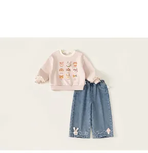 Dettaglio della felpa rosa con motivi cartoon e pantaloni di jeans blu per bambine