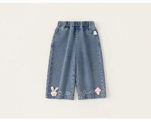 Dettaglio dei pantaloni larghi in denim blu per bambini con ricami di coniglio e fungo