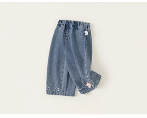 Dettaglio di pantaloni in denim azzurro per bambine con ricami di ciliegie e cuori