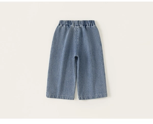 Dettaglio dei pantaloni larghi in denim azzurro per bambini con vita elastica comoda