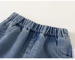 Dettaglio dei pantaloni in denim blu per bambini con vita elastica e tasche laterali